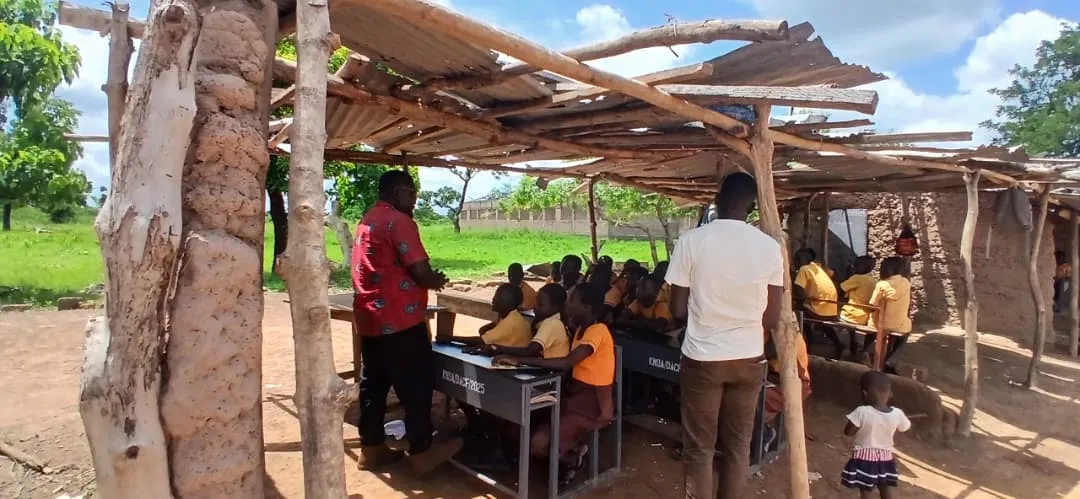 Teaching under an open shelter at Bawah-Doh D/A Primary School, a school with no proper classroom